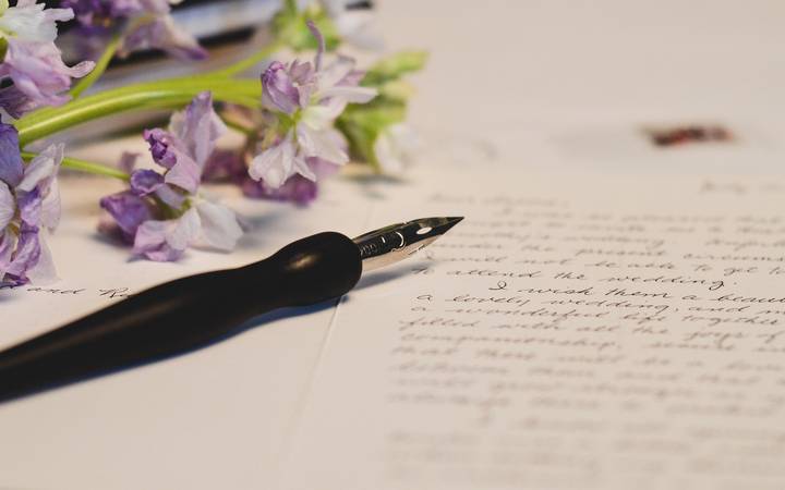 Plume posée sur une lettre manuscrite